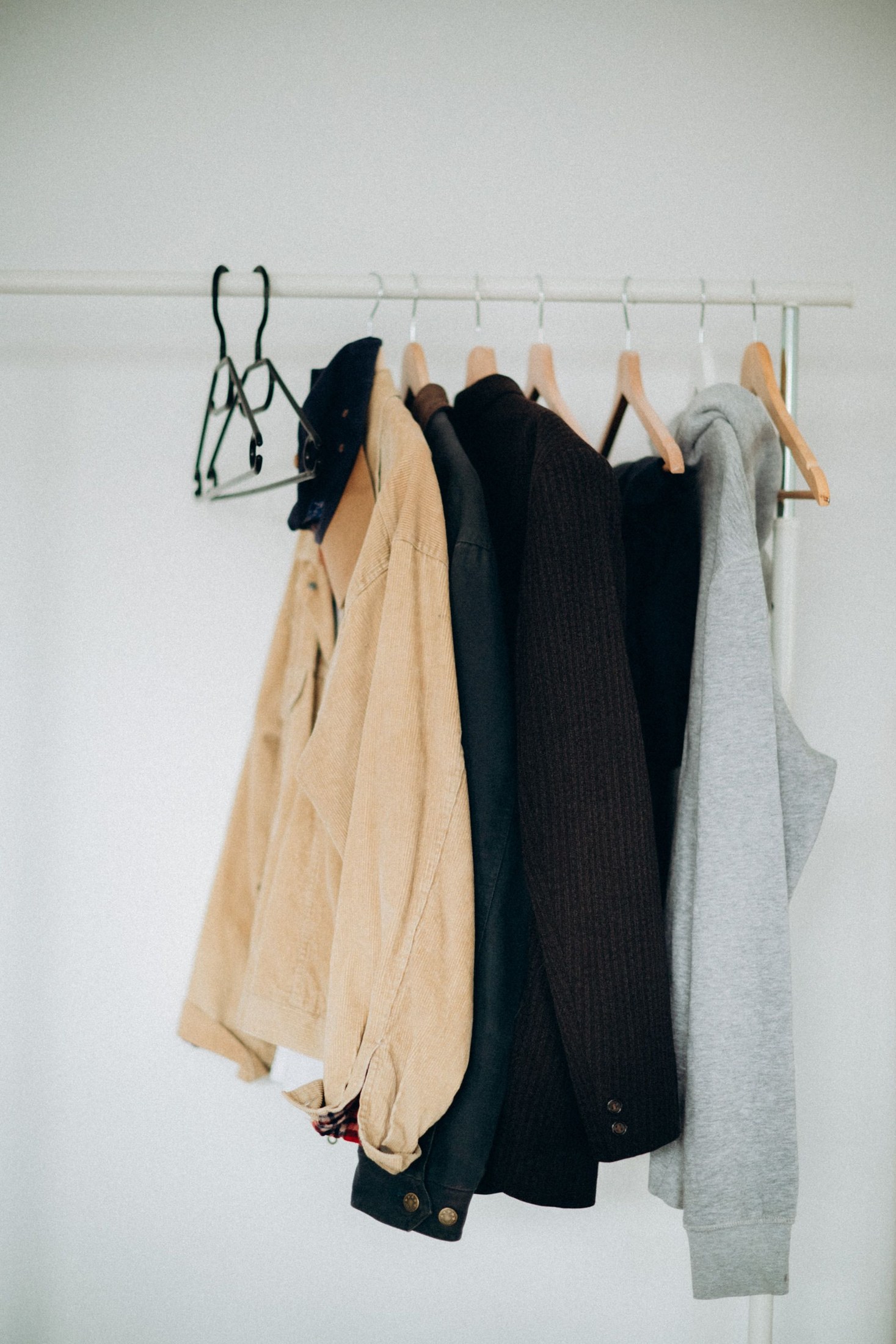Several different garments on a small wall-mounted rail
