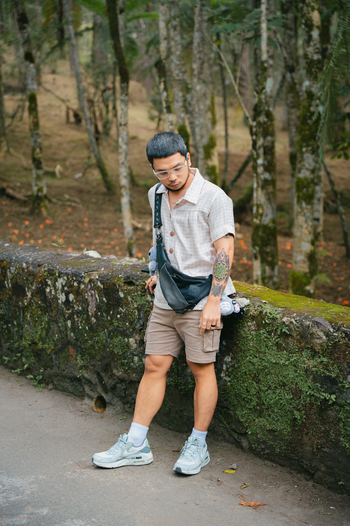A man in casual warm-weather clothing beside a forest path