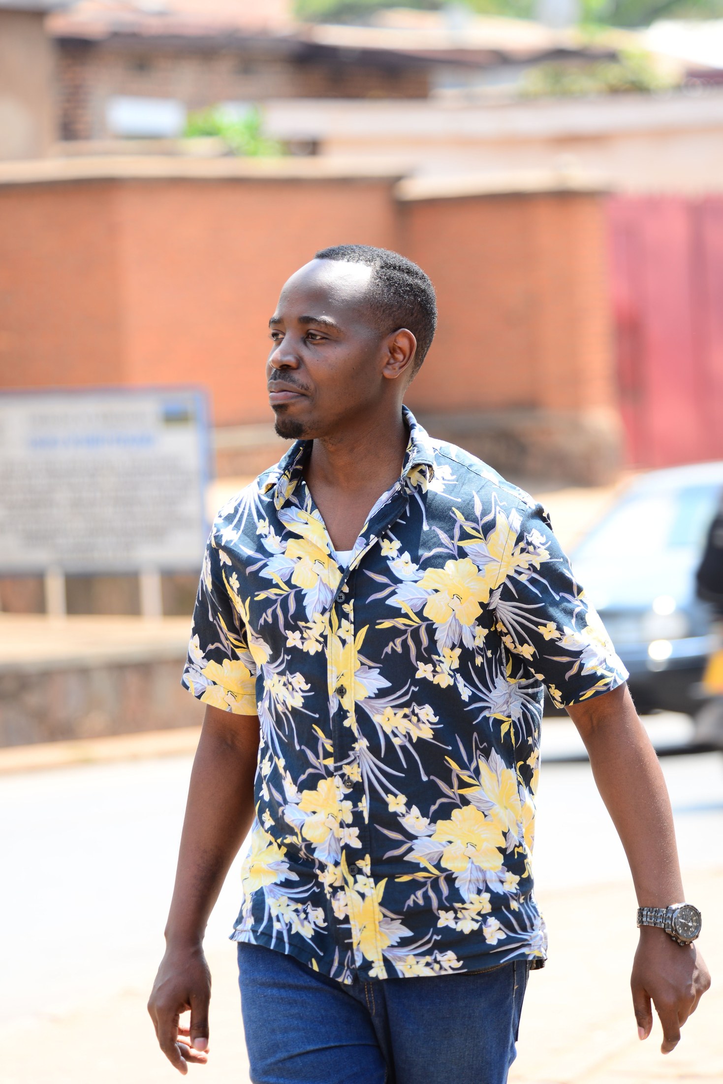A man wearing a relaxed floral shirt while walking in the city
