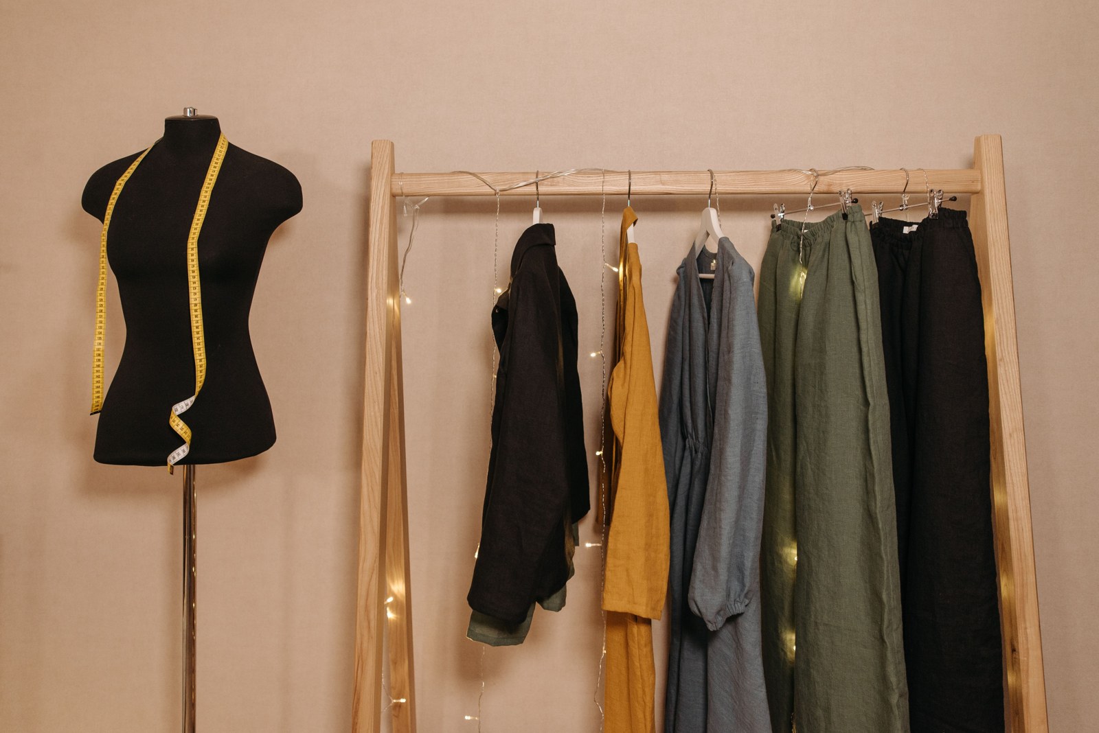 A clothing rail, mannequin and measuring tape in a garment workspace