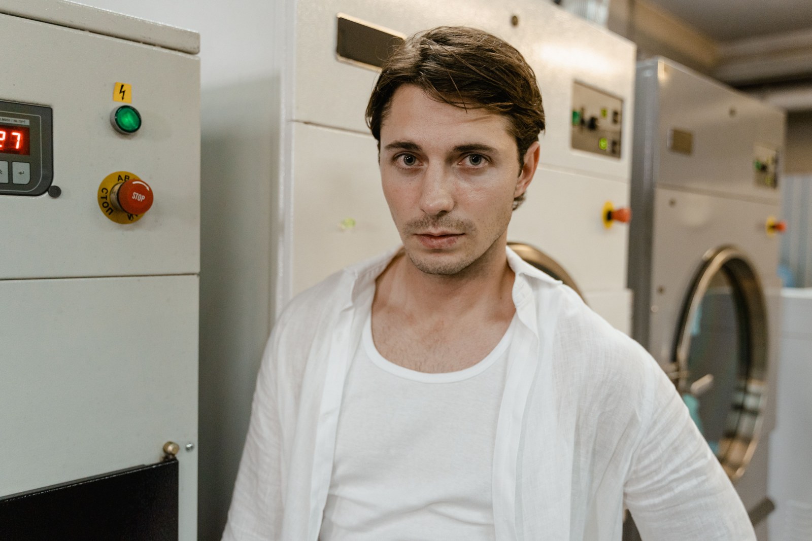A man in a white shirt in a laundry facility